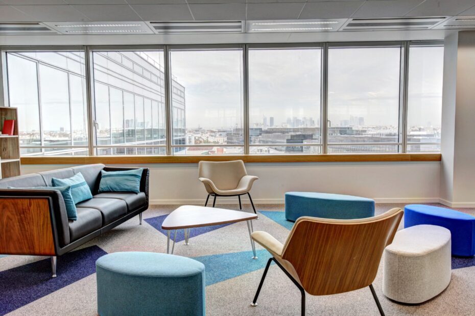 Sala de conferencias con mesa blanca rectangular y sillas de madera en espacio moderno y sobrio